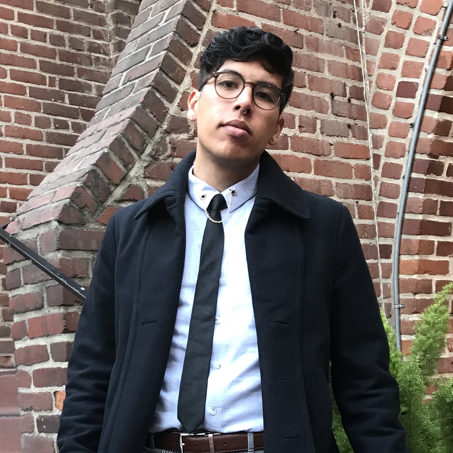 Man with dark hair and glasses wearing suit and tie